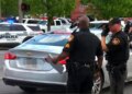 Police officers standing near vehicles at a crime scene in Toledo, Ohio