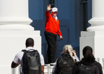 U.S. President Donald Trump waves as he returns to the White House, in Washington