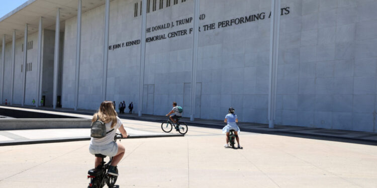 Cyclists ride by the Kennedy Center in Washington