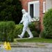 A man in a white hazmat suit walks out of a house in Stade, Germany.