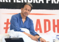 Activist Sonam Wangchuk - wearing a blue shirt - looks sideways as he sits on a hunger strike in Delhi