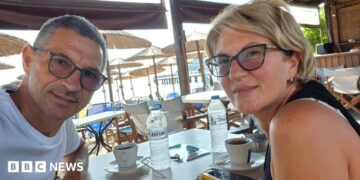 Karovic Ljubisa and his wife Svetlana Grković, smiling for a photo in a bar which appears to be at a holiday resort
