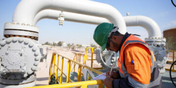 A worker checks equipment at the Rumaila oil field in Basra