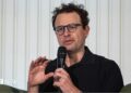 Anthropic chief executive Dario Amodei speaks through a microphone during a summit