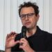 Anthropic chief executive Dario Amodei speaks through a microphone during a summit