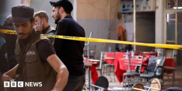 Syrian emergency services personnel work at the site a bomb blast at a cafe in central Damascus, Syria (2 July 2026)