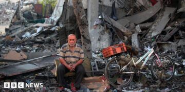 A Palestinian man rests amid debris at the site of an Israeli strike on a house in Gaza City, on July 30, 2026.