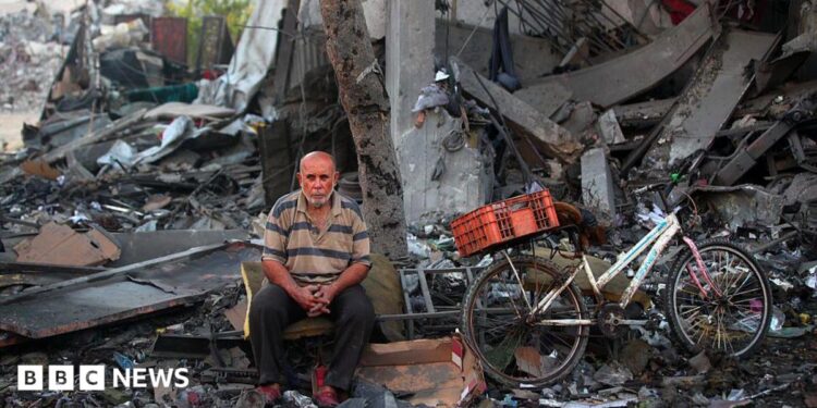 A Palestinian man rests amid debris at the site of an Israeli strike on a house in Gaza City, on July 30, 2026.