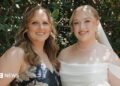 Hannah and her mother at Hannah's wedding. Her mother is wearing a blue dress with white flowers. Hannah on the right is dressed in a white wedding dress holding a bouquet