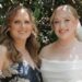 Hannah and her mother at Hannah's wedding. Her mother is wearing a blue dress with white flowers. Hannah on the right is dressed in a white wedding dress holding a bouquet