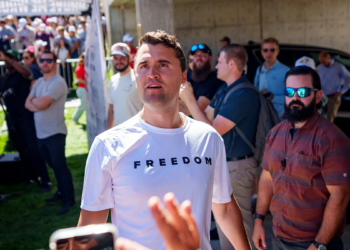 Charlie Kirk in a white T-shirt emblazoned with the word