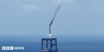 A screengrab of  a Long March 10B booster rocket landing on a recovery platform.