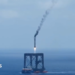 A screengrab of  a Long March 10B booster rocket landing on a recovery platform.
