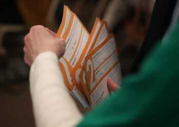 Precinct worker gathers Iowa Democratic Caucus paper ballots for counting after a Democratic presidential Caucus in West D...