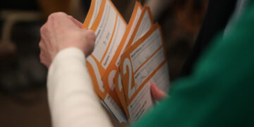 Precinct worker gathers Iowa Democratic Caucus paper ballots for counting after a Democratic presidential Caucus in West D...
