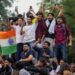 Abhijeet Dipke, head of the Cockroach Janta Party (CJP), celebrates with supporters who stand on an elevated platform holding their hands up in triumph