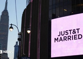 A poster of Taylor Swift  holding up a guitar outside Madison Square Garden, next to crush barriers saying "welcome to the Garden".