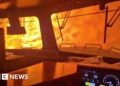 A train is surrounded by wildfire.