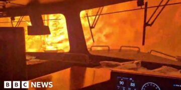 A train is surrounded by wildfire.