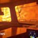 A train is surrounded by wildfire.