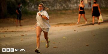 A person runs as the fire spreads in the mountains of Navaluenga, Avila, Spain