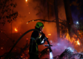 A firefighter works at the scene of a wildfire, in Andernos-les-Bains in the Gironde department, amongst worsening drought conditions following a heatwave and water shortages across much of France, July 26, 2026