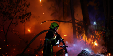A firefighter works at the scene of a wildfire, in Andernos-les-Bains in the Gironde department, amongst worsening drought conditions following a heatwave and water shortages across much of France, July 26, 2026