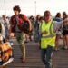A volunteer gives indication to holidaymakers from Lege-Cap-Ferret upon their arrival in Arcachon by boat during an evacuation operation of the entire Cap-Ferret peninsula, in southwestern France, on July 24, 2026 whilst a wildfire is spreading across the area