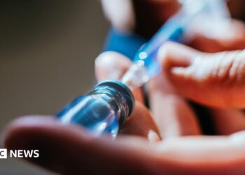 A close up of a person's hands as they prepare an injection