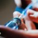 A close up of a person's hands as they prepare an injection