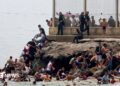 Spanish soldiers stand guard and intervene as migrants arrived swimming to Spanish territory of Ceuta on May 18, 2021