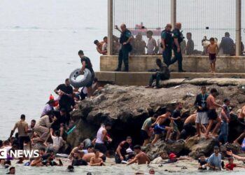 Spanish soldiers stand guard and intervene as migrants arrived swimming to Spanish territory of Ceuta on May 18, 2021