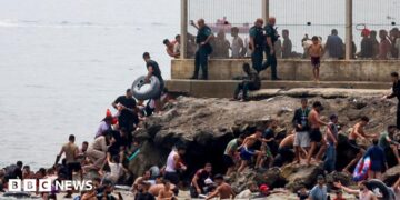 Spanish soldiers stand guard and intervene as migrants arrived swimming to Spanish territory of Ceuta on May 18, 2021