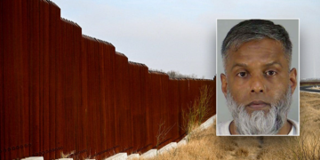 Composite image showing a tall steel U.S.-Mexico border wall with an inset booking photo of a gray-haired man with a full gray-and-white beard wearing a white shirt.