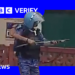 A still from a video of a rapid action force officer in Delhi, raising what experts say is a pellet gun.
