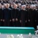 Iranian President Masoud Pezeshkian, Iran's Parliament speaker Mohammad Baqer Qalibaf and Chief Justice of Iran Gholam-hossein Mohseni Ejei with officials attend a prayer during a public farewell ceremony to pay their respects to late Supreme Leader Ayatollah Ali Khamenei. A large crowd can be seen in the background as everyone stands looking at the coffin