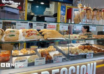 Food stall in Napoli with shelves stocked with sandwiches, pasta, bread, and fried foods