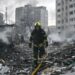 Sarah Rainsford in a brown shirt with short sleeves in front of rubble in Kyiv