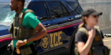 ICE agents secure the entrance to Delaney Hall detention center as demonstrators remain gathered in Newark