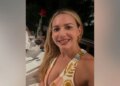 Judge Ashlee Cole smiles while seated at a restaurant table with a glass of red wine and a rose in front of her.