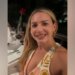 Judge Ashlee Cole smiles while seated at a restaurant table with a glass of red wine and a rose in front of her.