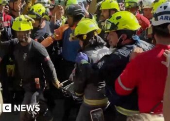 Group of rescuers holding man on stretcher