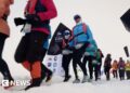 Runners set off from the snowy starting line in full thermal gear and goggles