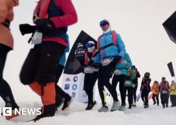 Runners set off from the snowy starting line in full thermal gear and goggles
