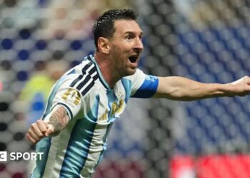 Lionel Messi celebrating with his arms out for Argentina