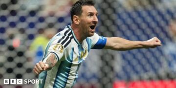 Lionel Messi celebrating with his arms out for Argentina