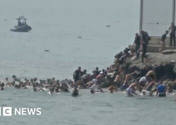 People in the water swimming, group of people climbing rocks