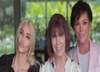 This photo shows Kim, her daughter, Mary Jo and Kris posing together smiling. They are standing by some bright pink flowers.