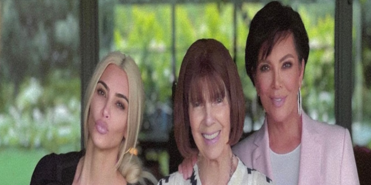 This photo shows Kim, her daughter, Mary Jo and Kris posing together smiling. They are standing by some bright pink flowers.