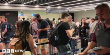 People move through the queue for the Entry Exit System process at Fuimicino Airport in Rome, Italy.